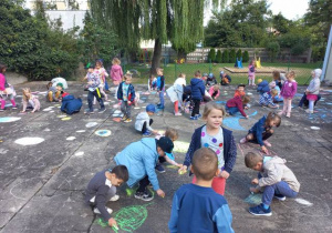Dzieci ze wszystkich grup malują kropki na tarasie